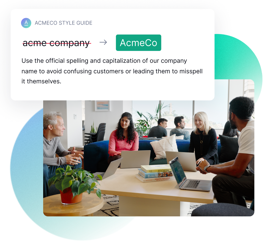Smiling colleagues sit around a table in an open plan office.